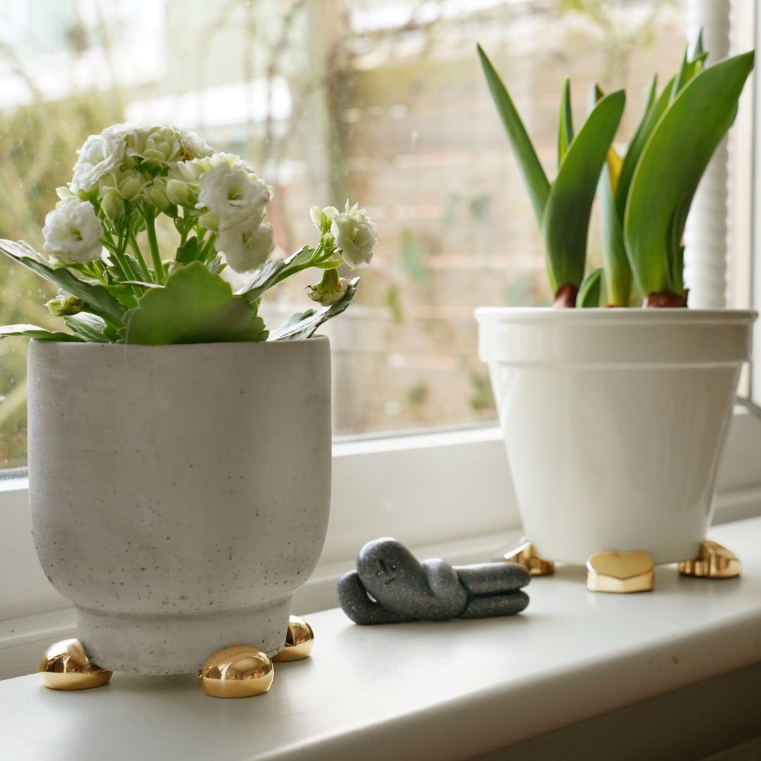 Vita krukor på fönsterbräda med krukfötter